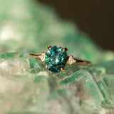 1.98ct Oval Precision Cut Teal Montana Sapphire and Princess Cut Diamond Rapids Low Profile Ring in 14k Yellow Gold